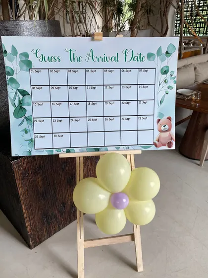 Interactive fun for a baby shower. We designed this 'Guess The Arrival Date' game board on an easel, decorated with a small balloon flower, to get guests involved in the celebration.