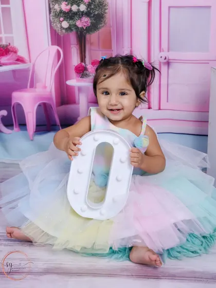 A perfect smile while holding the letter 'O'. These alphabet props are a fun way to personalize a first birthday shoot.