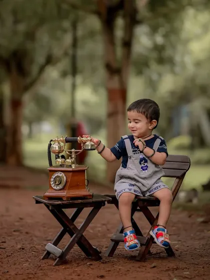 A curious glance as he reaches for the phone. I let children interact with props naturally, which leads to authentic portraits that truly reflect their inquisitive nature at this age.