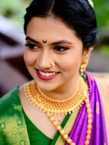 A close up portrait of Poorva that beautifully showcases her traditional Maharashtrian nose ring (nath) and gold necklace.