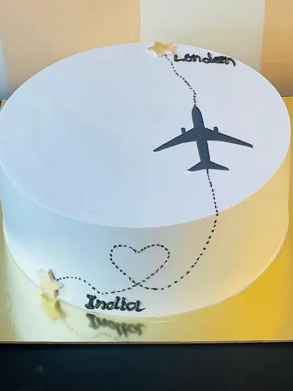 A minimalist and elegant farewell cake for someone moving from India to London. The design beautifully captures the theme of travel and new beginnings.