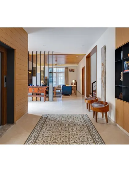 The passage in Nataraj House, where an oak-finished wood cladding defines the lift core, and a patterned tile rug adds interest to the walkway.