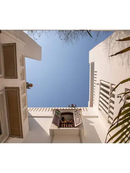 The deep plan of the building is pierced by whitewashed courtyards that bring daylight and fresh air down to the basement level. These courtyards are the lungs of the building, allowing for natural ventilation and evaporative cooling.