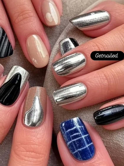 This set showcases a variety of chrome and metallic designs on each nail. From solid silver chrome to abstract black and silver patterns, it's a great example of a customized, edgy look.