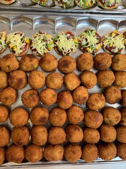 A tray of Mini Veggie Pizzas and Corn & Cheese Balls, two of the most requested items for birthday parties.