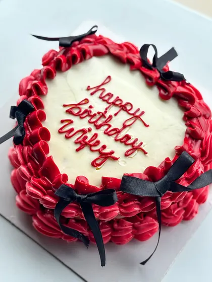 I love a good vintage buttercream and bow moment. This design features rich red buttercream piping with delicate black bows, perfect for a romantic and stylish "happy birthday wifey" cake.