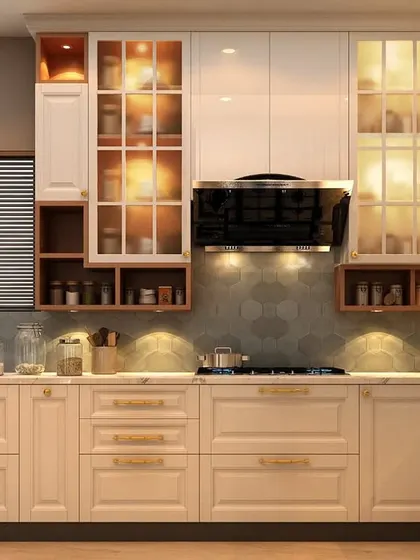This classic kitchen design features cream-colored cabinets with elegant molding and a beautiful tile backsplash. The glass-front upper cabinets with interior lighting are perfect for showcasing fine crockery.