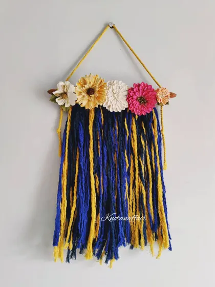 A full view of the simple and colorful macrame wall hanging. It's an eco-friendly and sustainable decor piece, made with cotton cords on a wooden dowel. I can customize it in any colors and size.