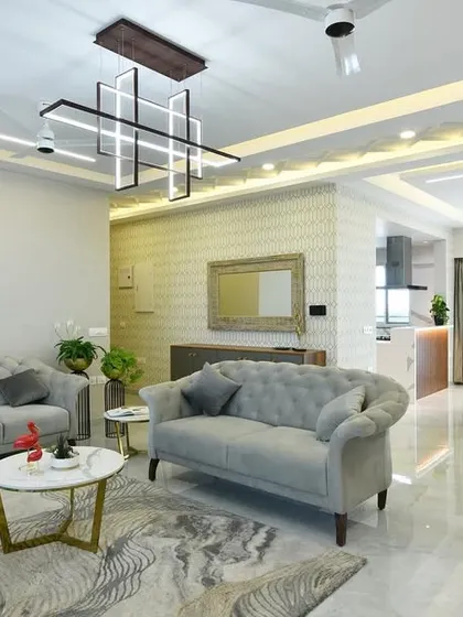 The final executed living room, bringing the 3D render to life. The space features elegant tufted sofas, a modern geometric chandelier, and a harmonious color palette, demonstrating our commitment to delivering on our design promise.