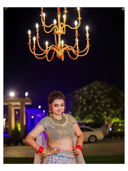 A stylish portrait of the bride under a chandelier. Her confident pose and stunning lehenga make for a modern and fashionable bridal shot.