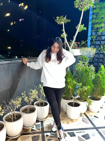 Looking down, showing the relaxed fit of the hoodie. This highlights the comfort aspect of the outfit.