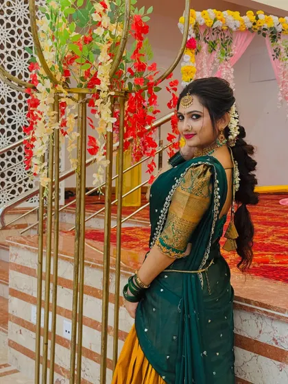 A side profile showing the graceful drape of the dupatta and the floral hair accessory, completing this traditional look.
