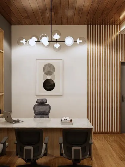 A view of the executive desk area in the Sankalp office concept. The large, open bookshelf provides ample storage and display space, while the modern chandelier adds a touch of elegance.