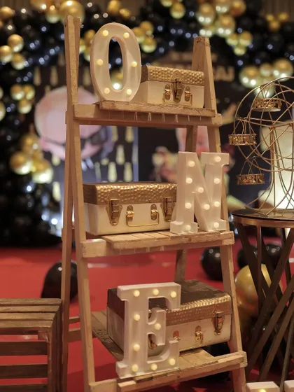 The "ONE" marquee letters displayed on a rustic wooden ladder shelf. This is a creative way to showcase the milestone age as part of the overall decor.