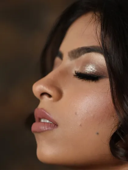 A close-up profile, showing the flawless skin and soft, shimmery eye makeup.