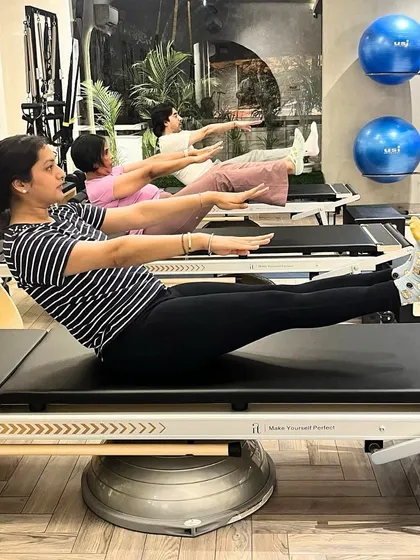 The 'hundred' is a classic Pilates exercise that warms up the body and deeply engages the core. Our clients demonstrate perfect form on the Reformer.