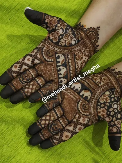 A striking design with a band of white-highlighted elephants that really pops. The rest of the hand is covered in a mix of floral and geometric patterns, creating a modern-traditional fusion.