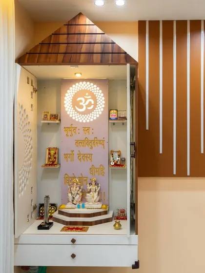 A closer view of the temple-style pooja unit, showing the intricate details and the warm lighting that creates a serene ambiance.