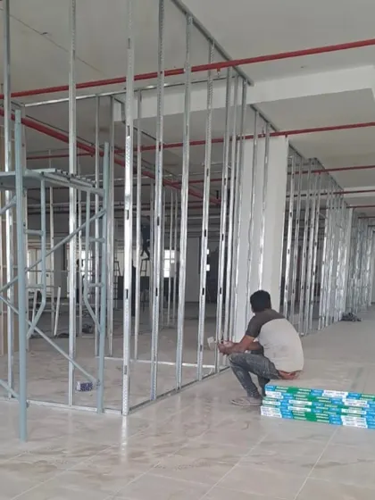 A worker installing drywall framing at the DHL office site.