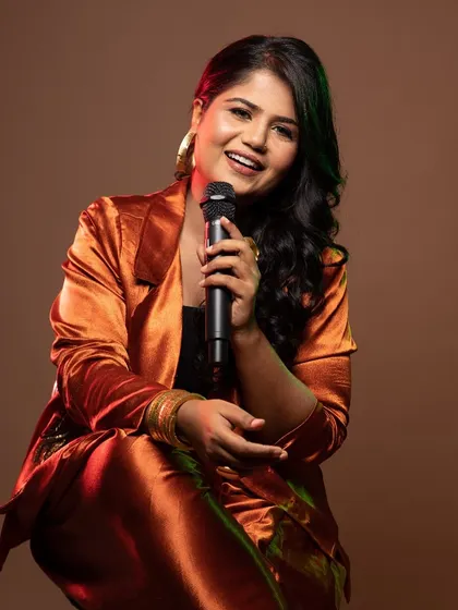 A beautiful portrait of the singer, with warm-toned makeup that complements the bronze outfit.