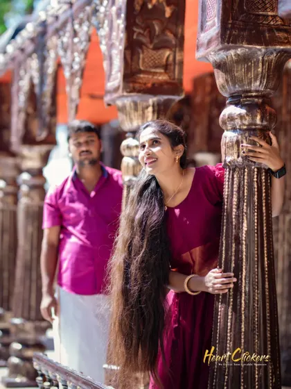 The bride looks up with a smile while standing on a traditional wooden balcony, creating a natural and happy portrait.