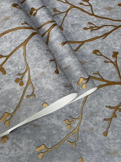 A grey wallpaper roll with a metallic bronze branch pattern, showing the texture and sheen.
