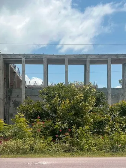 The concrete frame of the Weaver's Training Facility seen from the road. The simple, robust structure is designed to be a flexible and functional space for artisans, preserving an ancient art and providing a platform for creativity.