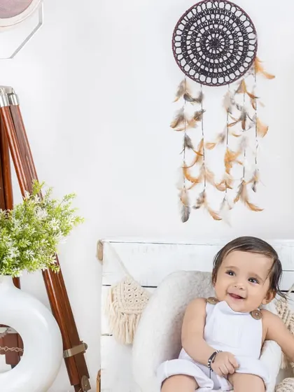 A happy baby boy in a white outfit, enjoying our simple and clean lifestyle set.
