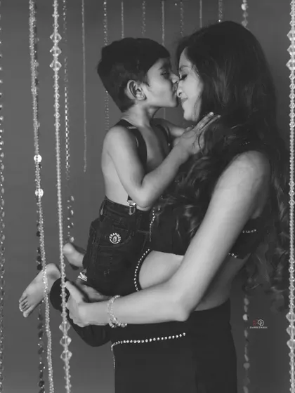 A tender kiss from a big brother, captured in classic black and white. This style makes the moment feel even more precious and heartfelt.