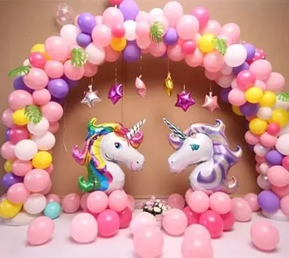 A magical unicorn themed party with a pastel balloon arch and two large unicorn head foil balloons.