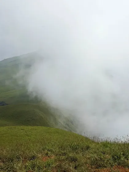 The dense fog rolling in, completely transforming the landscape during a winter trek to Nethravathi.