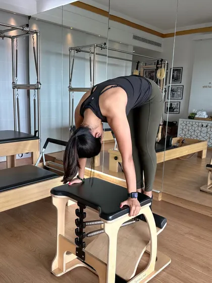 A deep stretch on the Wunda Chair. This piece of equipment is incredibly versatile, allowing for movements that challenge balance, strength, and flexibility all at once.