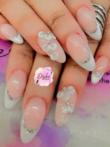 A delicate and pretty design. This set features a soft pink base with a classic French tip, accented with tiny 3D flowers for a touch of subtle elegance.