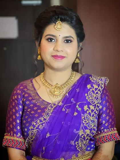 A classic portrait of Sheela, showcasing her complete engagement look with a traditional purple saree and gold jewelry.