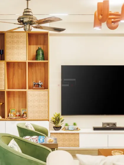 This angle shows the interplay between the olive green accent chairs and the natural wood tones of the media unit, creating a balanced and earthy color scheme.