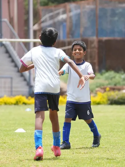 Teammates celebrating a goal during a friendly match in Ooty. The joy of playing together is what it's all about.
