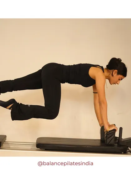 A floating plank on the reformer. This advanced move requires immense core control and upper body strength.