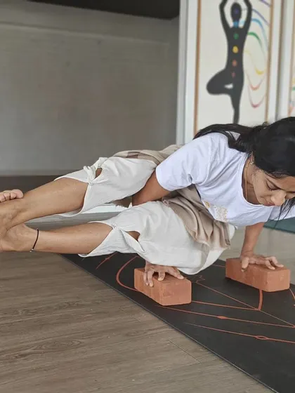Advanced arm balances like Astavakrasana (Eight-Angle Pose) are taught with careful guidance in our TTC. Students learn to use props like blocks to build strength and understand the pose's mechanics.