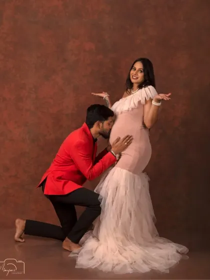 A fun and playful moment as the dad-to-be listens to the baby bump. The elegant setting adds a touch of sophistication to this sweet, candid-style shot.