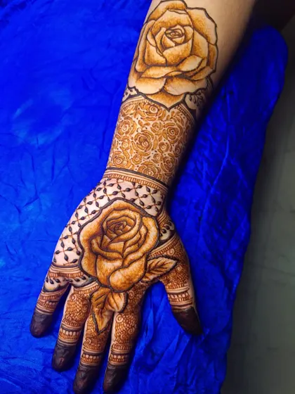 A practice piece blending contemporary and traditional styles. This design features a large, bold rose as the centerpiece on both the palm and the forearm, surrounded by classic patterns.