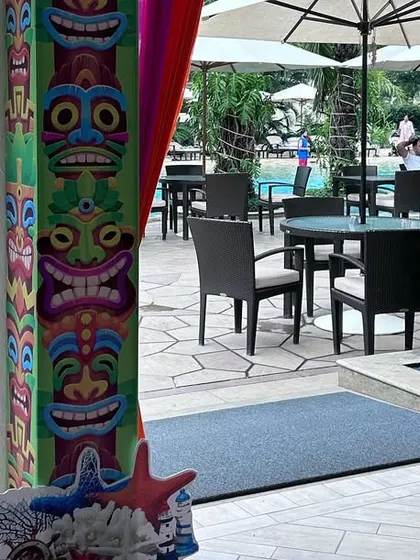 Thematic details extend to the entrance. For this beach party, we used tiki-style pillar wraps and a directional signpost with beach-related phrases to welcome guests into the themed environment.
