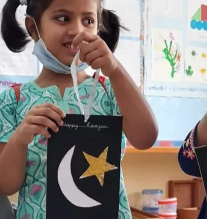 Two children proudly show their Ramadan lanterns. These activities help them learn about the symbols and traditions of other cultures.