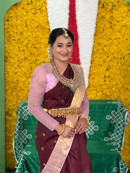 A full-length portrait of the client for her Srinivasa Kalyanam, looking elegant in a maroon saree.