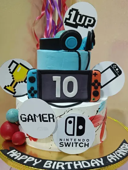 Level up your birthday with this Nintendo Switch gamer cake. The design features fondant joy-cons, a headset, and other gaming-related icons.