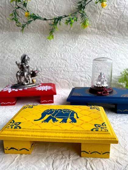 I made these pooja chowkis last year and they sold out. The designs include a floral pattern, a mandala, and a traditional elephant motif.