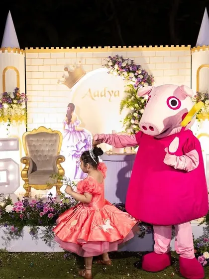 Even the mascots get in on the fun. Here, Peppa Pig joins the birthday girl for a photo in front of her magnificent castle, adding an extra layer of joy to the celebration.