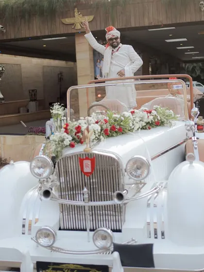 The groom arrives in style in a decorated vintage car. A classic car adds a touch of royalty and makes for a grand and photogenic baraat entry.