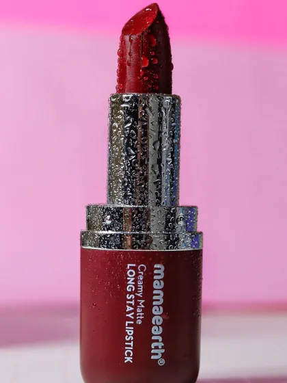 A full view of the Mamaearth Creamy Matte Long Stay Lipstick, with water droplets on the casing to give it a premium, fresh look.