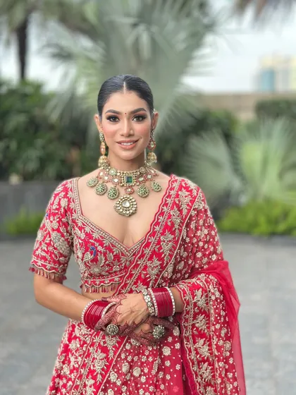 A full portrait of my beautiful bride in a classic red lehenga. I focused on creating a luminous skin finish and defined eyes to complement her traditional wedding attire and heavy jewellery, ensuring she looked absolutely regal.