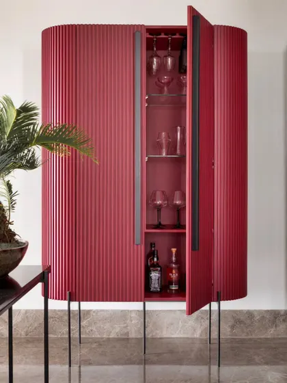 This vibrant red bar cabinet is a showstopper. Its fluted texture and curved form make it a piece of art, while providing elegant storage for glassware and spirits.